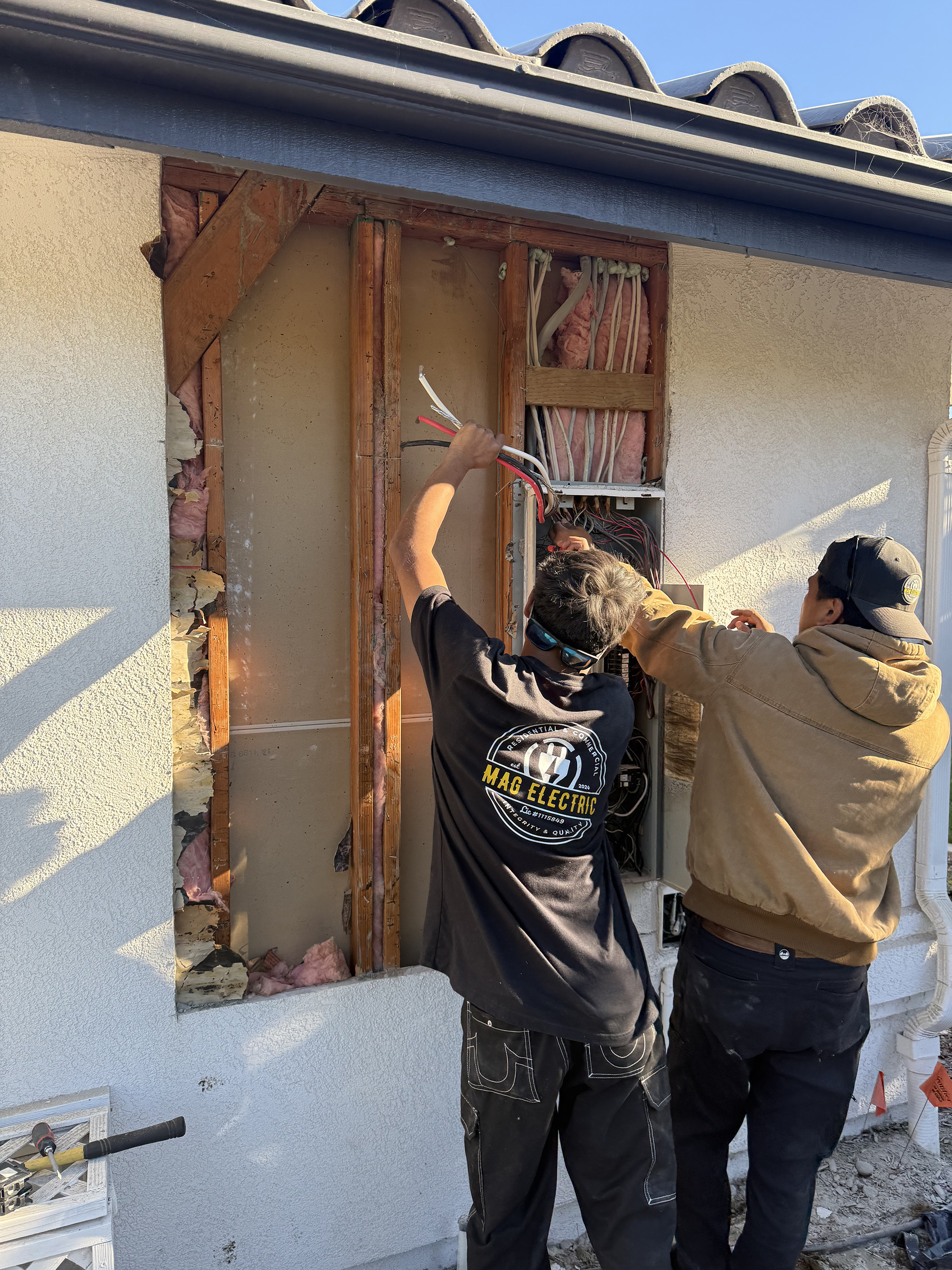 Electricians upgrading residential electrical panel on exterior wall Santa Barbara County